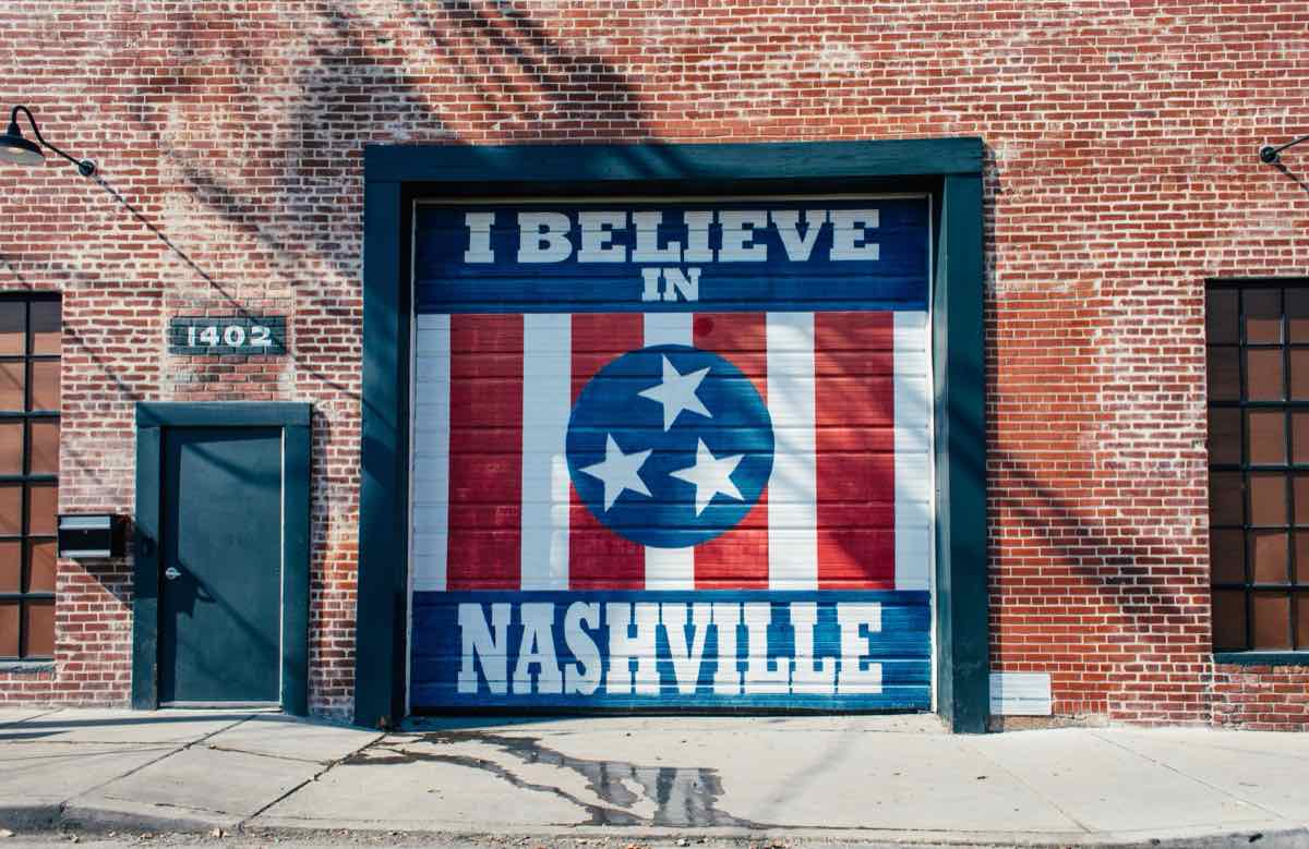 I Believe in Nashville mural painted on a garage door in a red brick wall