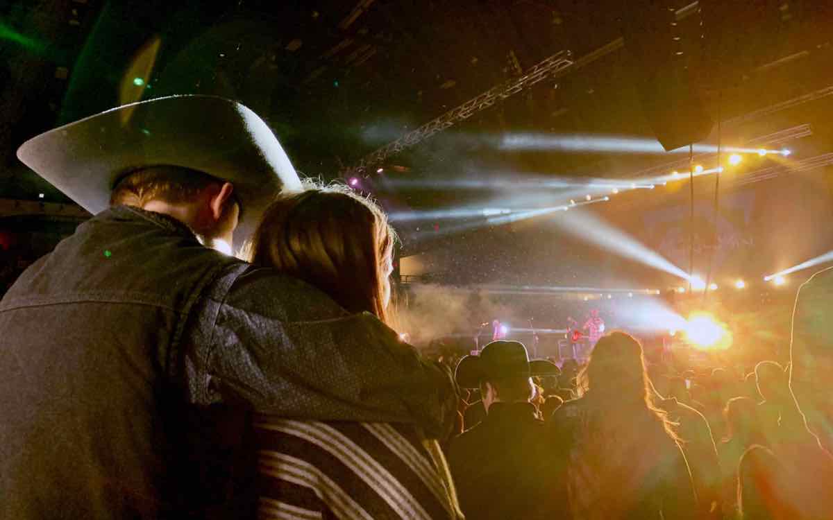 Couple in a cowboy hat watching a country concert at a Nashville music venue