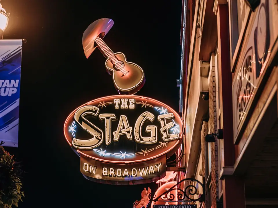 The Stage on Broadway neon guitar sign over the crowd on Lower Broadway at night