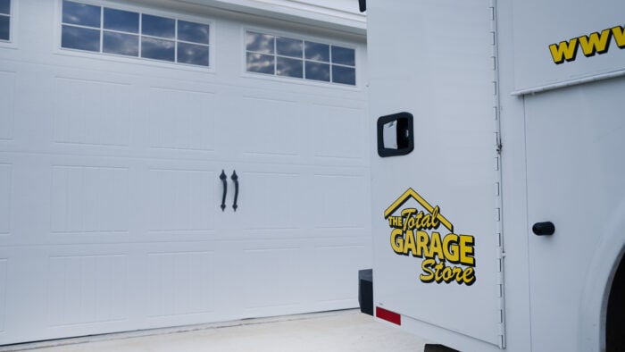 Branded company van beside a white garage door