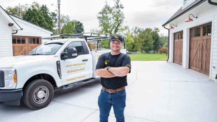 Team member in front of a company service truck