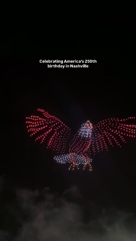 An eagle made of lit drones in the night sky over downtown