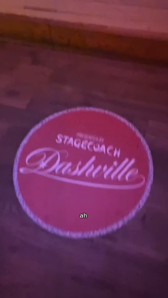 The Dashville logo projected in pink on the floor