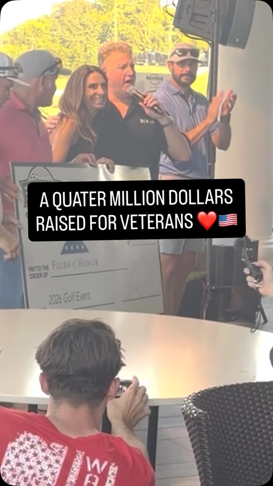 Gary LeVox with a microphone, announcing the donation