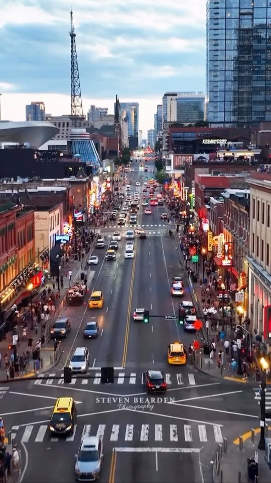 Lower Broadway at dusk from above, with traffic and neon