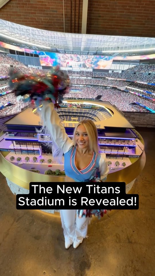 A Titans cheerleader with pom-poms in front of the new stadium model